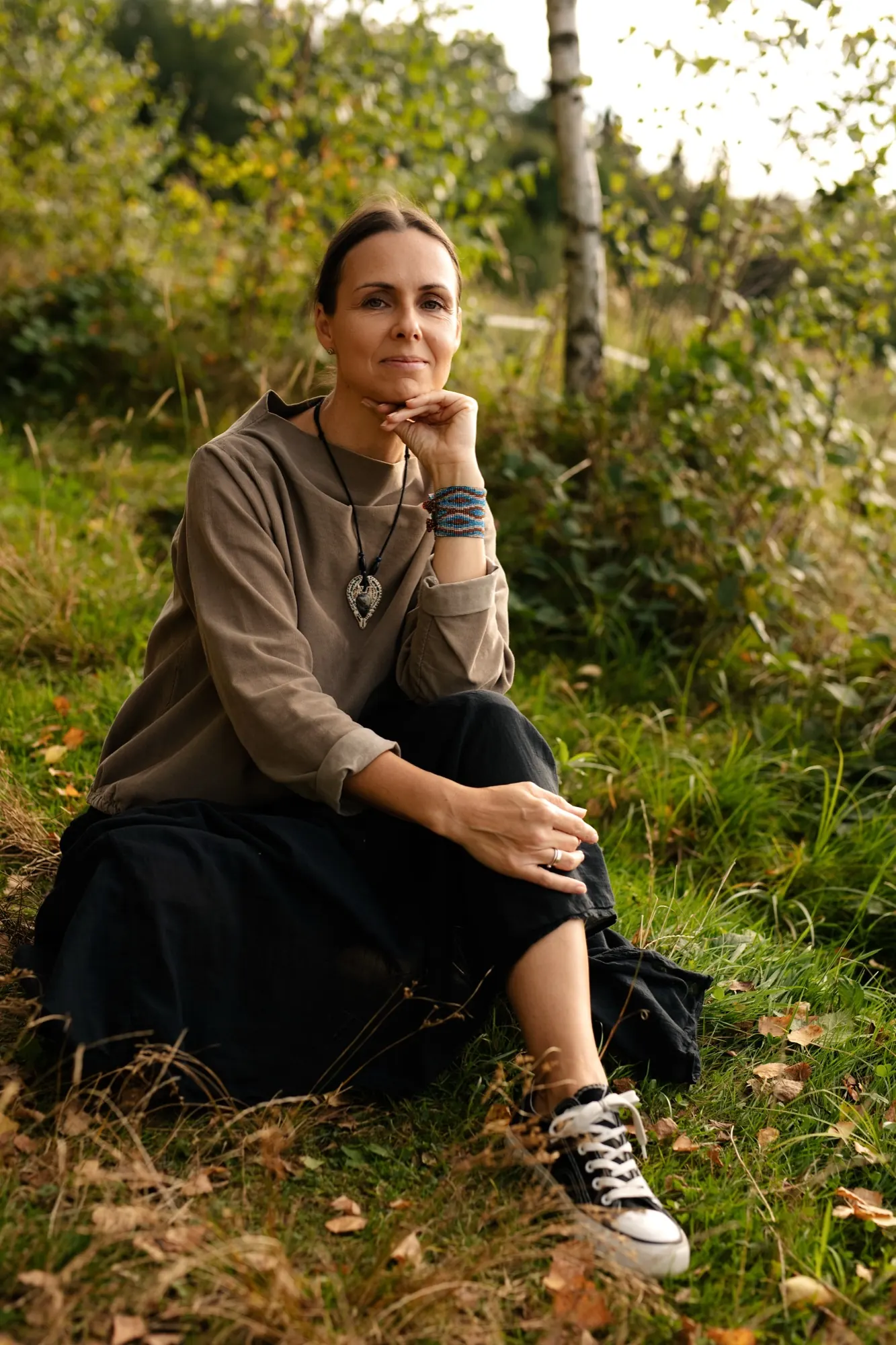Katarzyna Skupień siedzi na trawie i patrzy w obiektyw